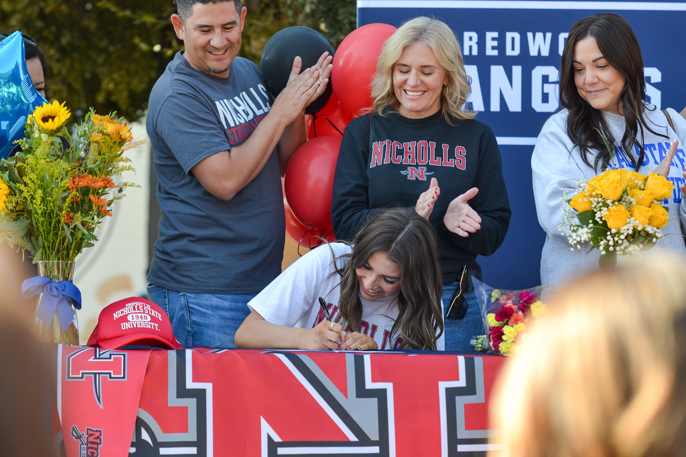 Fall Signing Day 2023 Photos from Signing Day at Redwood High School, taken on November 9, 2023. The images document the event where student athletes announce their commitments to college sports programs. Key moments include athletes signing commitment papers, interacting with coaches and family members, and their reactions during the event. The photographs aim to capture the significance of this day for the students and their supportive community.