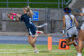 A Redwood ball carrier runs with the football, arms stretched out, near the end zone pylon as a Madera defender chases behind her.